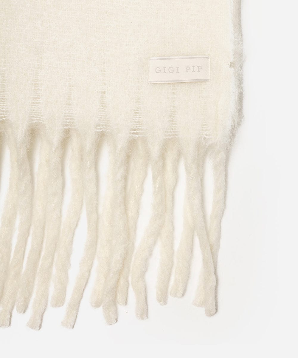 Close-up of a cream-colored scarf with fringe details on a white background. #color_off white