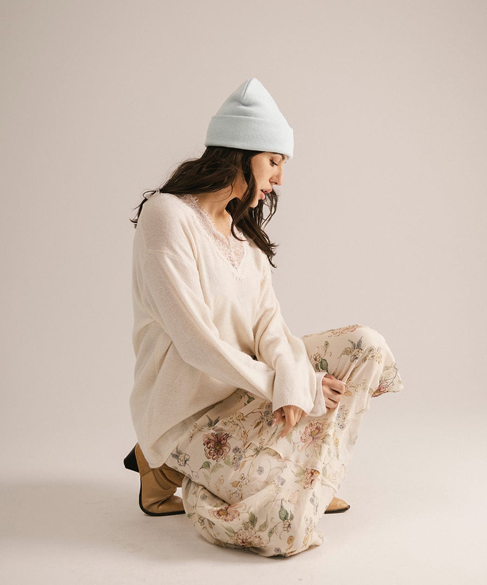 Woman wearing a light blue beanie and a floral dress on a plain background #color_sky blue