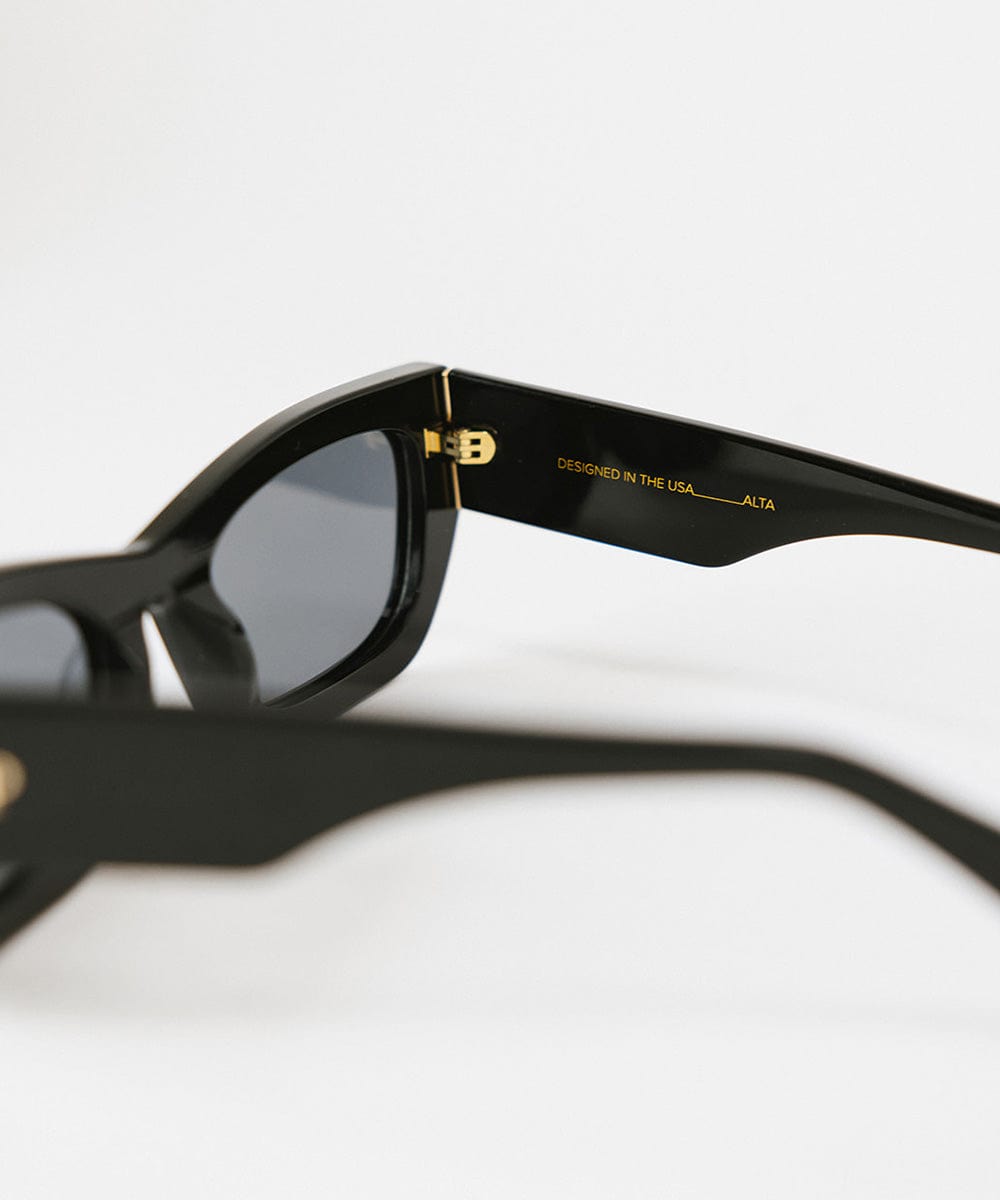 Close up image of black sunglasses on a plain background #color_black