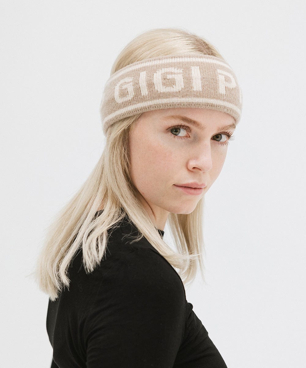 Woman wearing a taupe colored headband with 'GIGI PIP' text and a black t-shirt, posing against a plain background #color_taupe