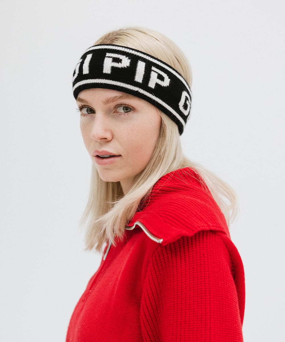 Woman wearing a black headband with 'GIGI PIP' text and a red jacket against a plain background #color_black