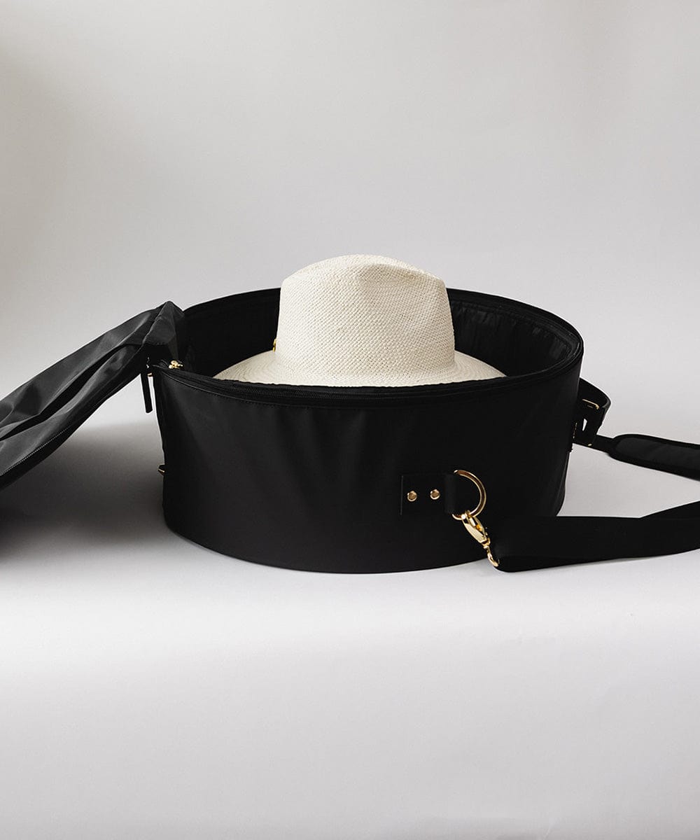 A black round hat travel case with a white hat inside against a plain background #color_black
