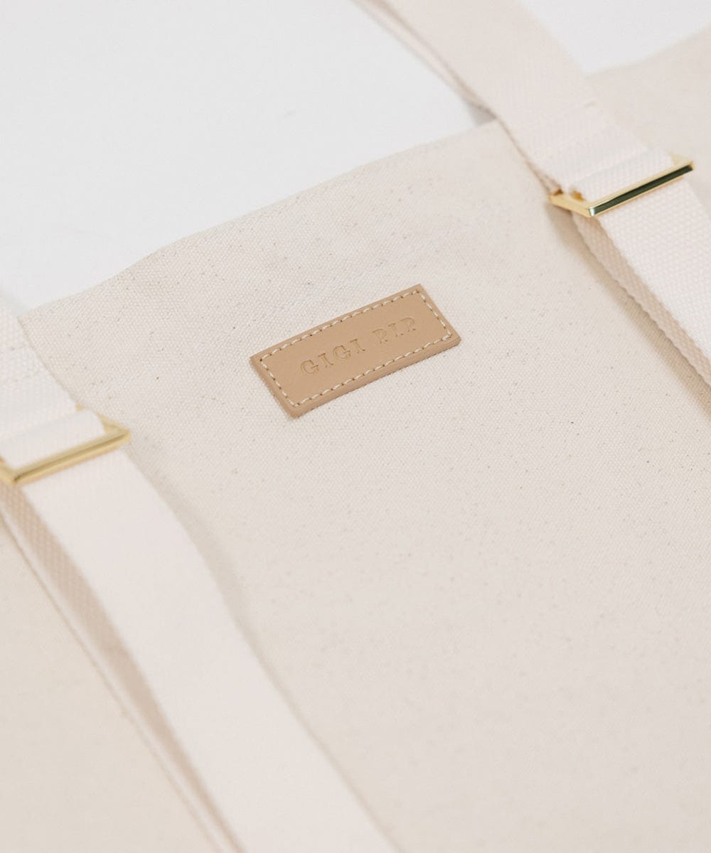 A natural colored Canvas Hat Carrying Tote Bag with the brand label #color_natural