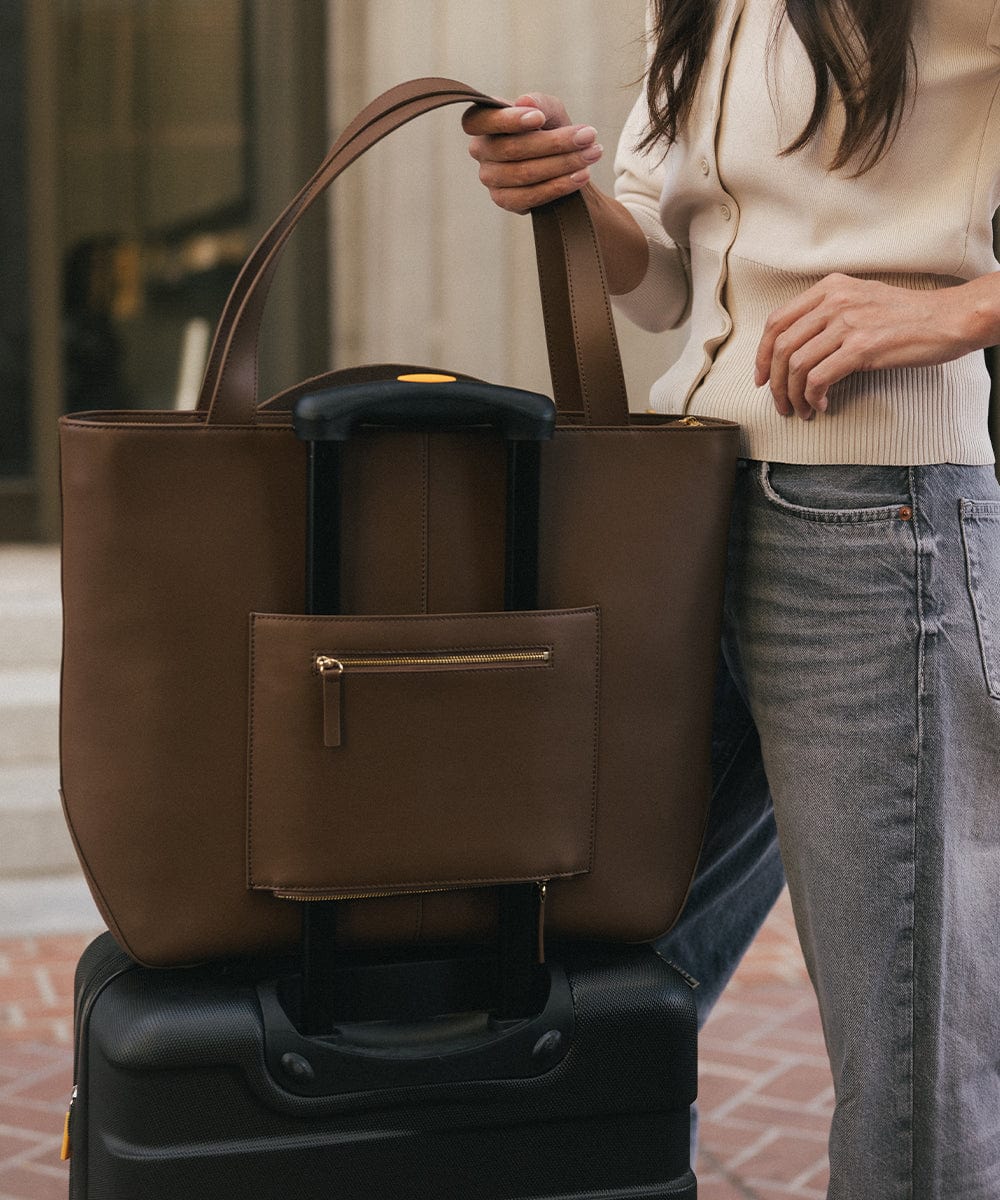 A brown Hayes Hat Carrying Tote made of genuine leather on a black suitcase #color_chocolate