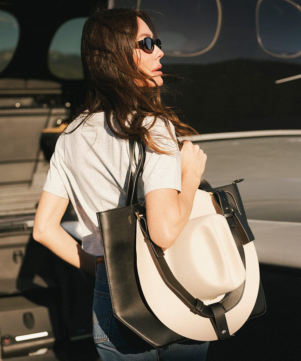 Person carrying a black Hayes Hat Carrying Tote bag with a white cowboy hat #color_black
