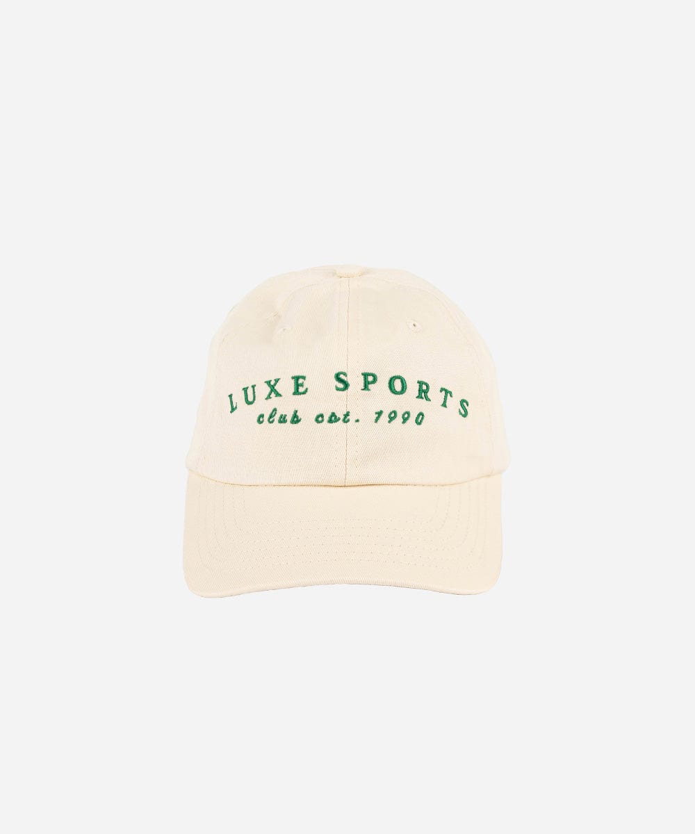 A cream ball cap with 'LUXE SPORTS' and 'club est. 1990' text on a white background #color_cream