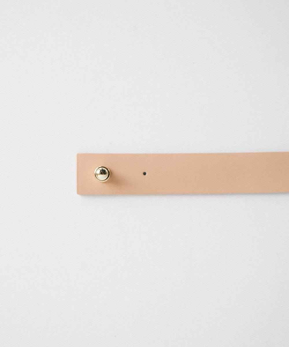 A nude leather band with pin on a plain background #color_nude