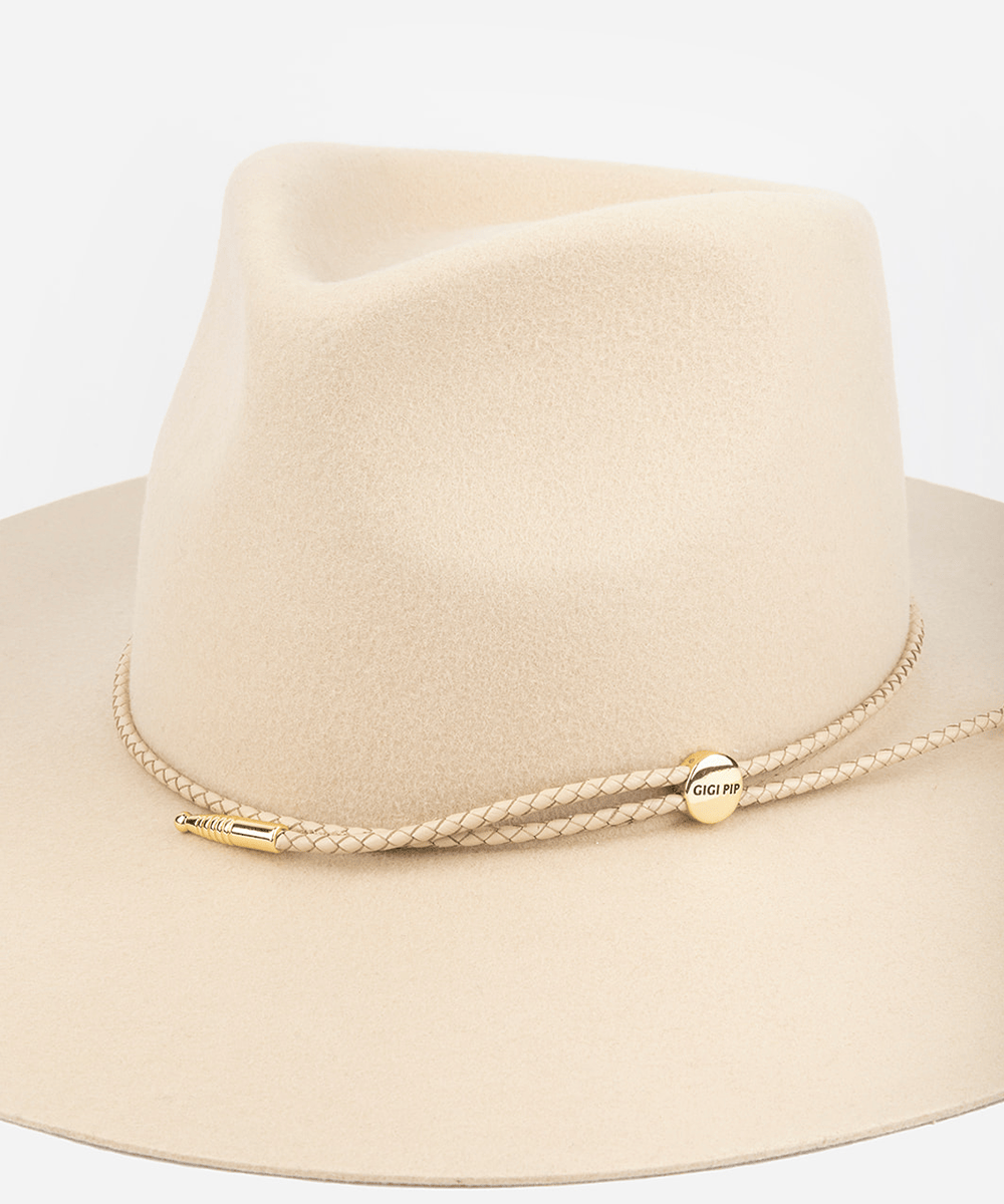 Beige fedora hat with thin braided wrap band on a white background #color_cream