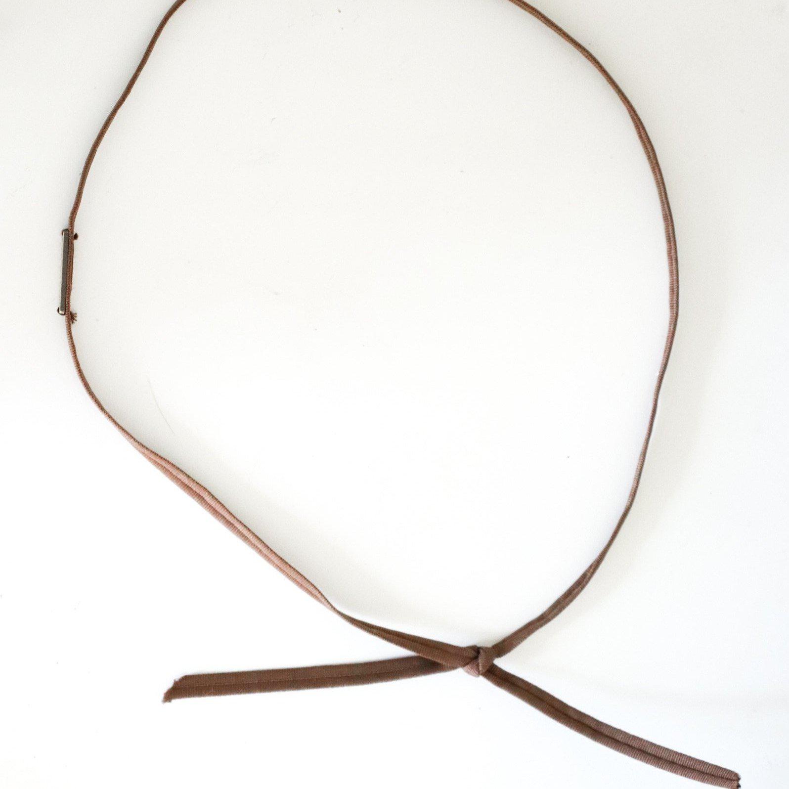 A chocolate brown colored grosgrain band on a plain background #color_chocolate brown