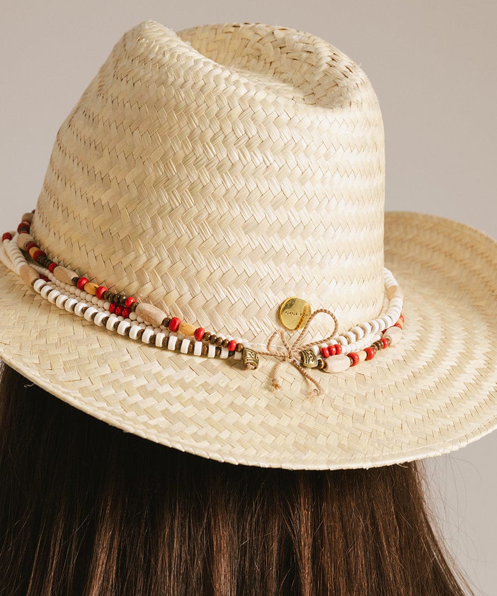 Close up image of a person wearing a beige hat with a natural colored layered beaded hat band against a plain background #color_natural