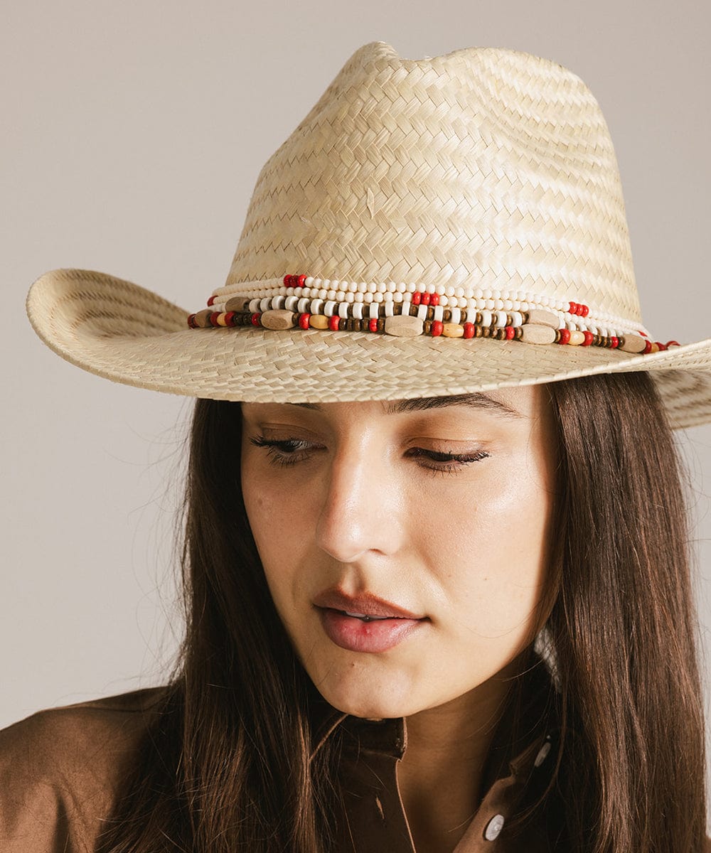 Woman wearing a beige hat with a natural colored layered beaded hat band against a plain background #color_natural