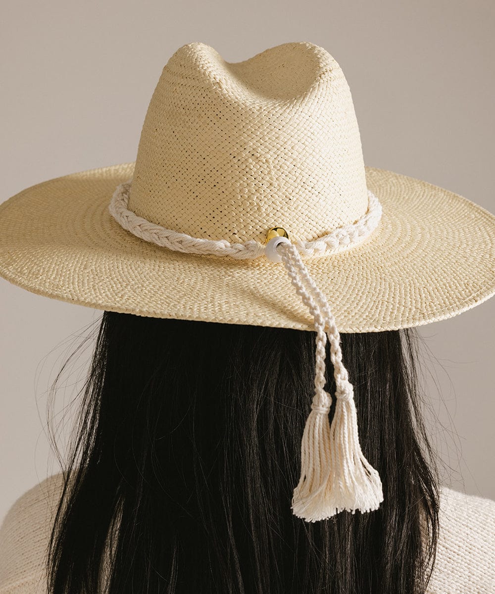 Woman wearing a beige cap with a natural white colored braided rope hat band facing behind against a plain background #color_natural white