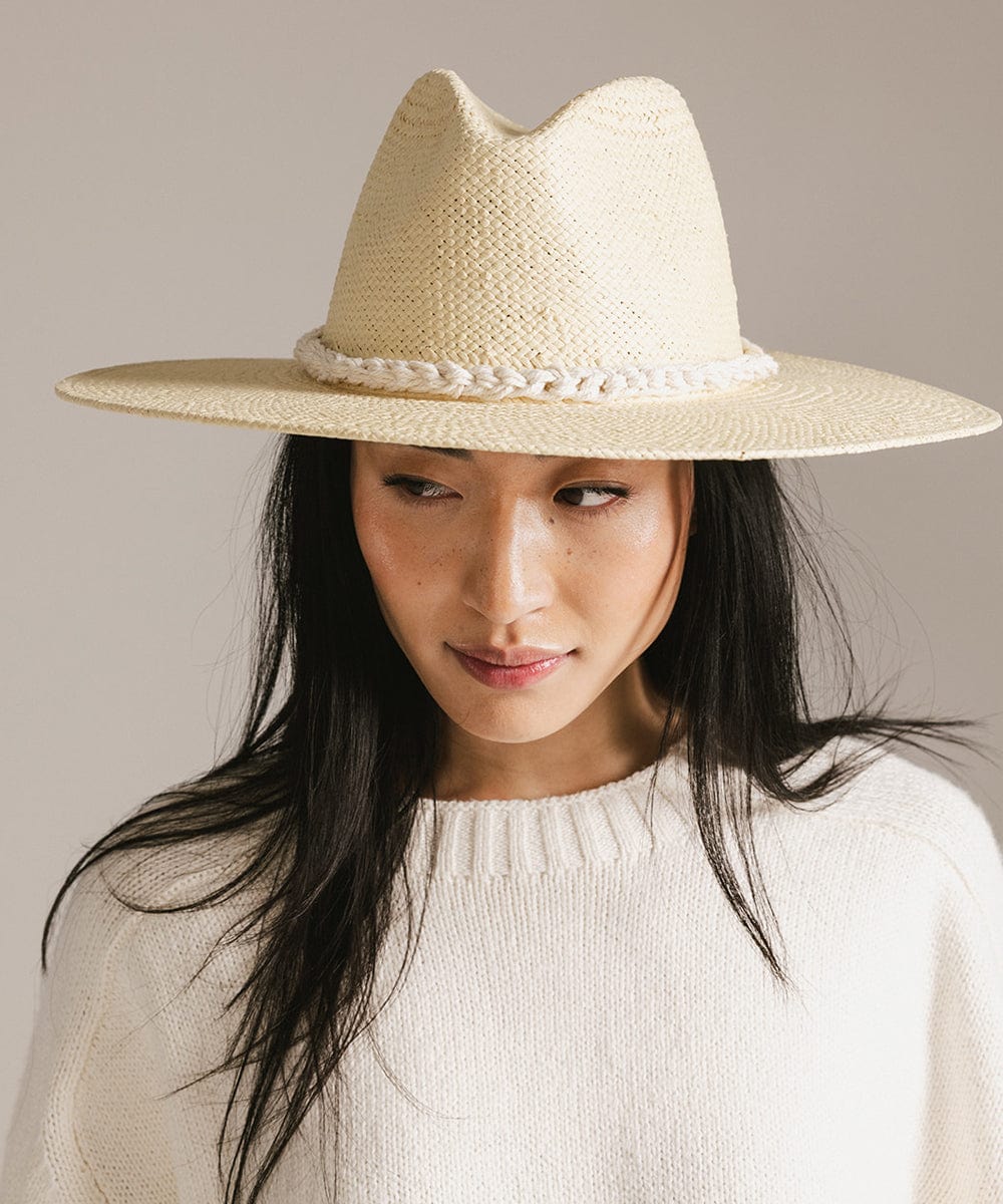Woman wearing a beige cap with a natural white colored braided rope hat band and a white sweater against a plain background #color_natural white
