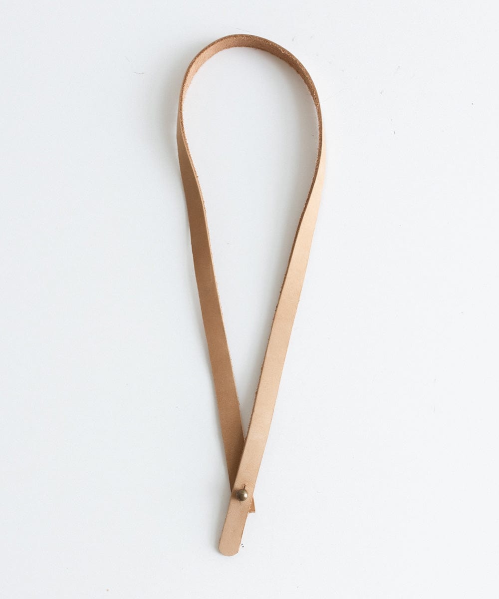 A nude thin leather band on a white background #color_nude