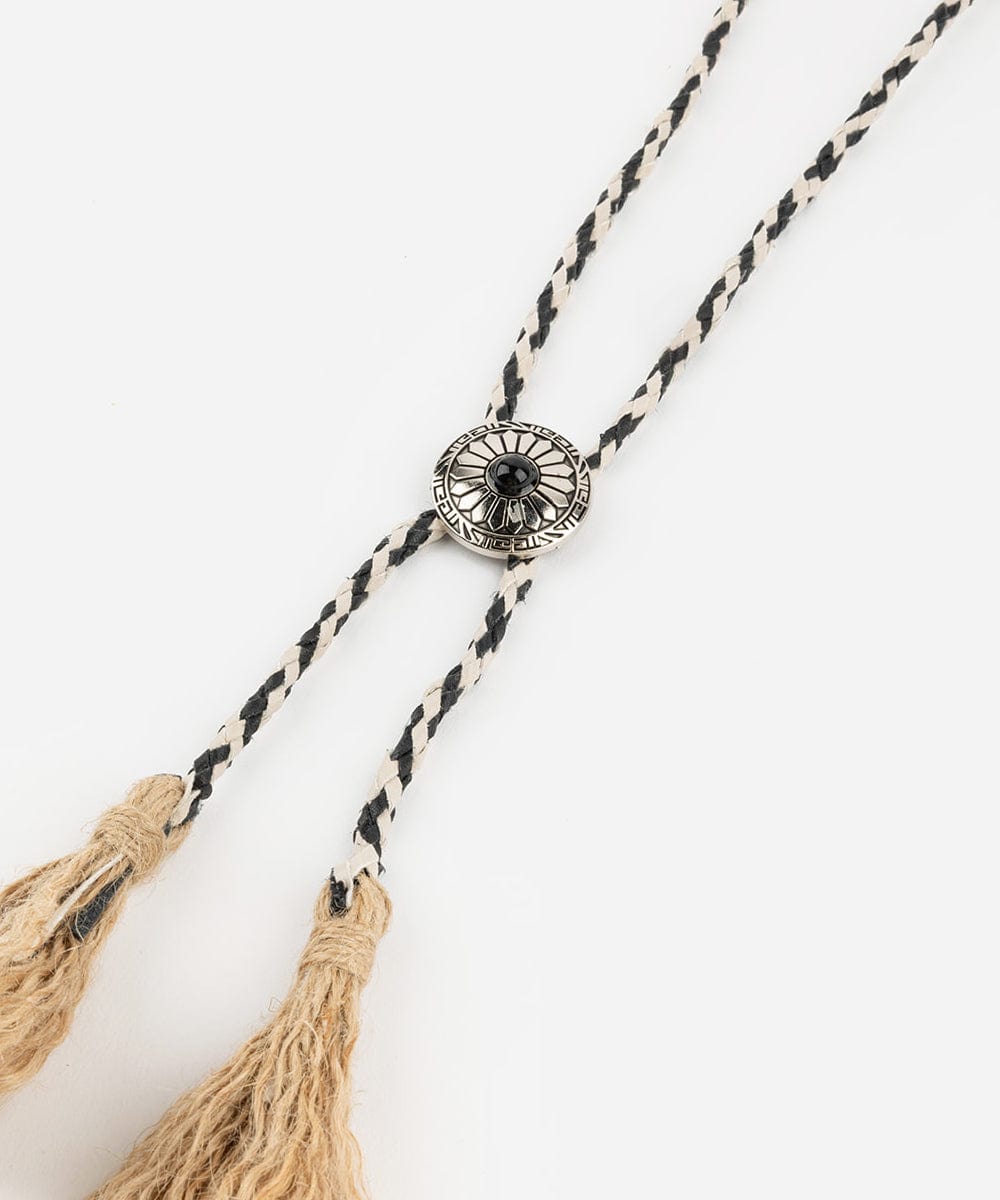 A black and white colored braided bolo tassel hat band on a plain background #color_white-black