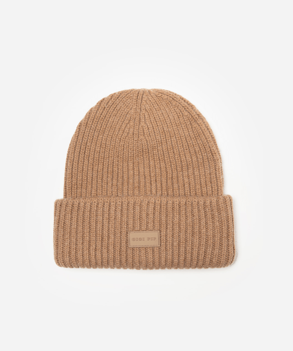 Brown knit beanie with a small label on a white background #color_brown