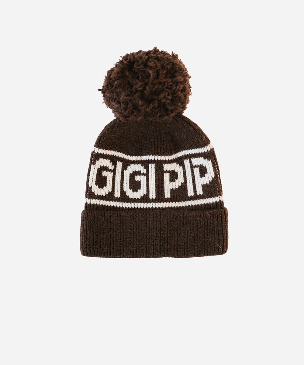 A chocolate brown colored knit beanie with pom-pom and 'GIGI PIP' branding on a white background #color_chocolate brown