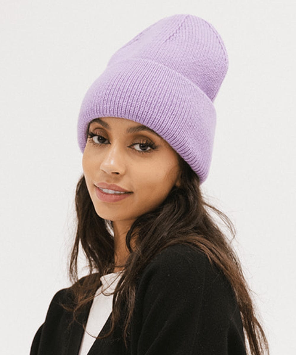 Woman wearing a lavender colored oversized knit beanie against a plain background #color_lavender