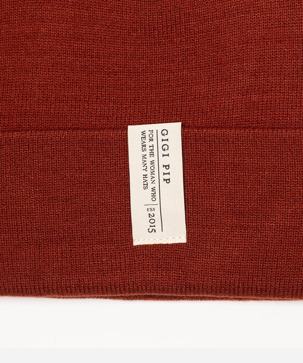 Close-up of a brown fabric with a Gigi Pip label on a white background #color_brick red