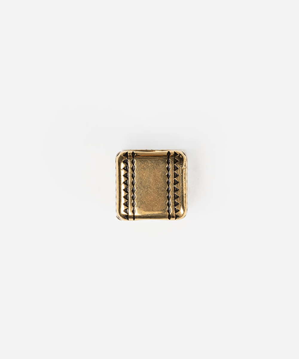 A single square metallic charm or bead with a textured, antiqued gold finish and decorative stitched-looking borders, centered on a plain white background #color_gold