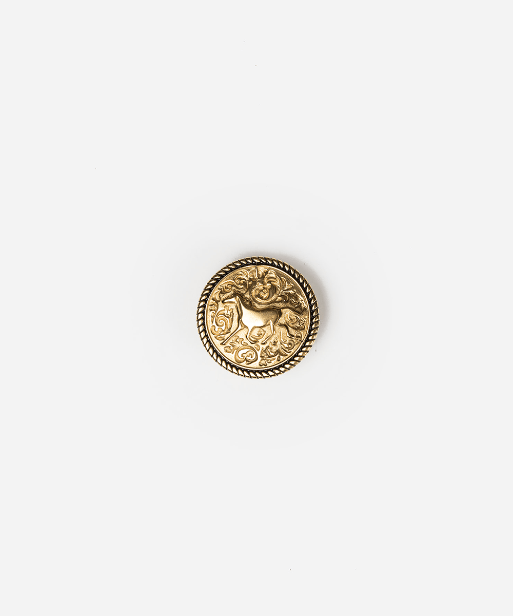 A single round gold-toned decorative button with an embossed animal motif and rope-style border, centered on a plain light gray background #color_gold