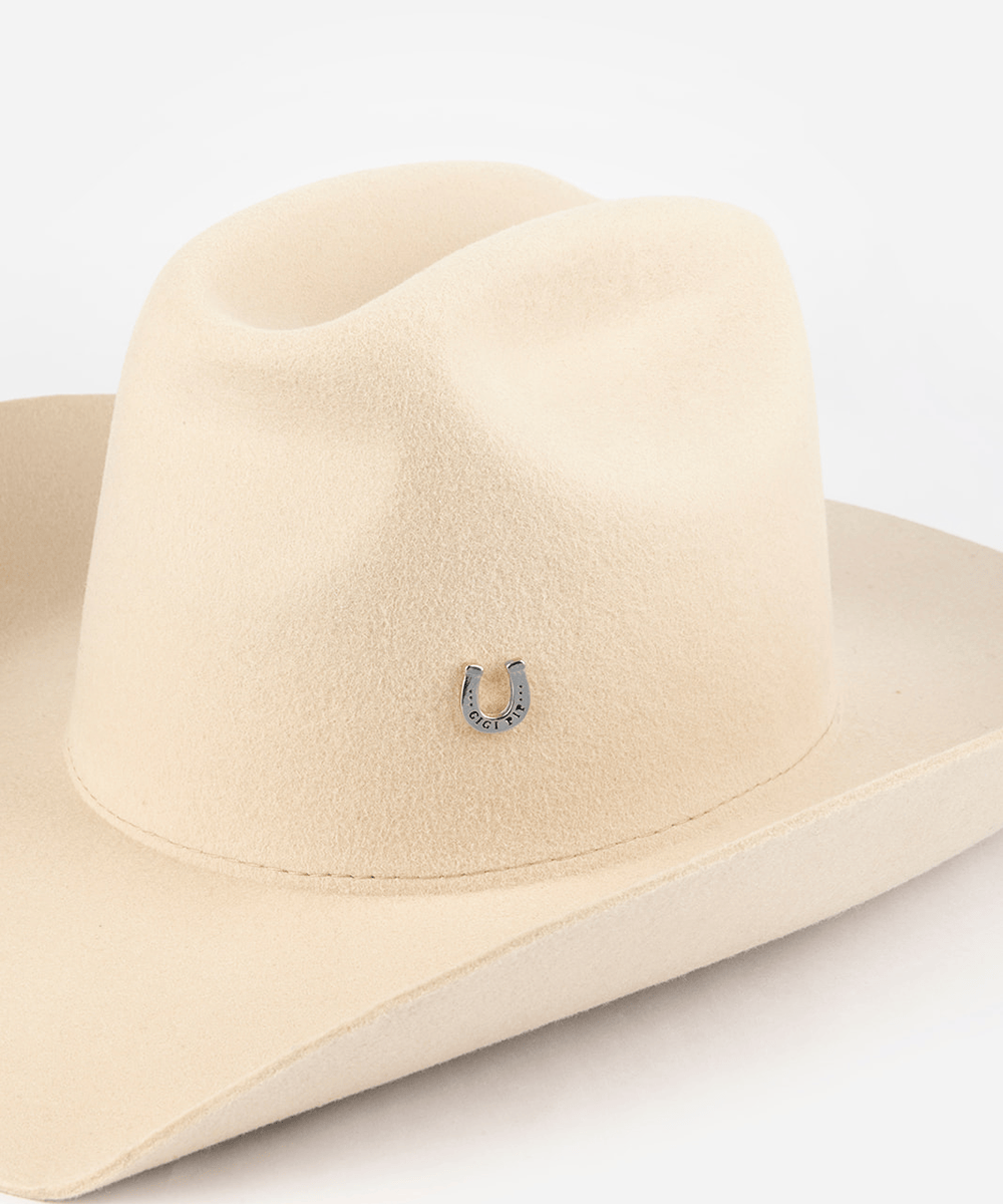 Pink cowboy hat with a silver horseshoe-shaped hat pin on a white background #color_silver