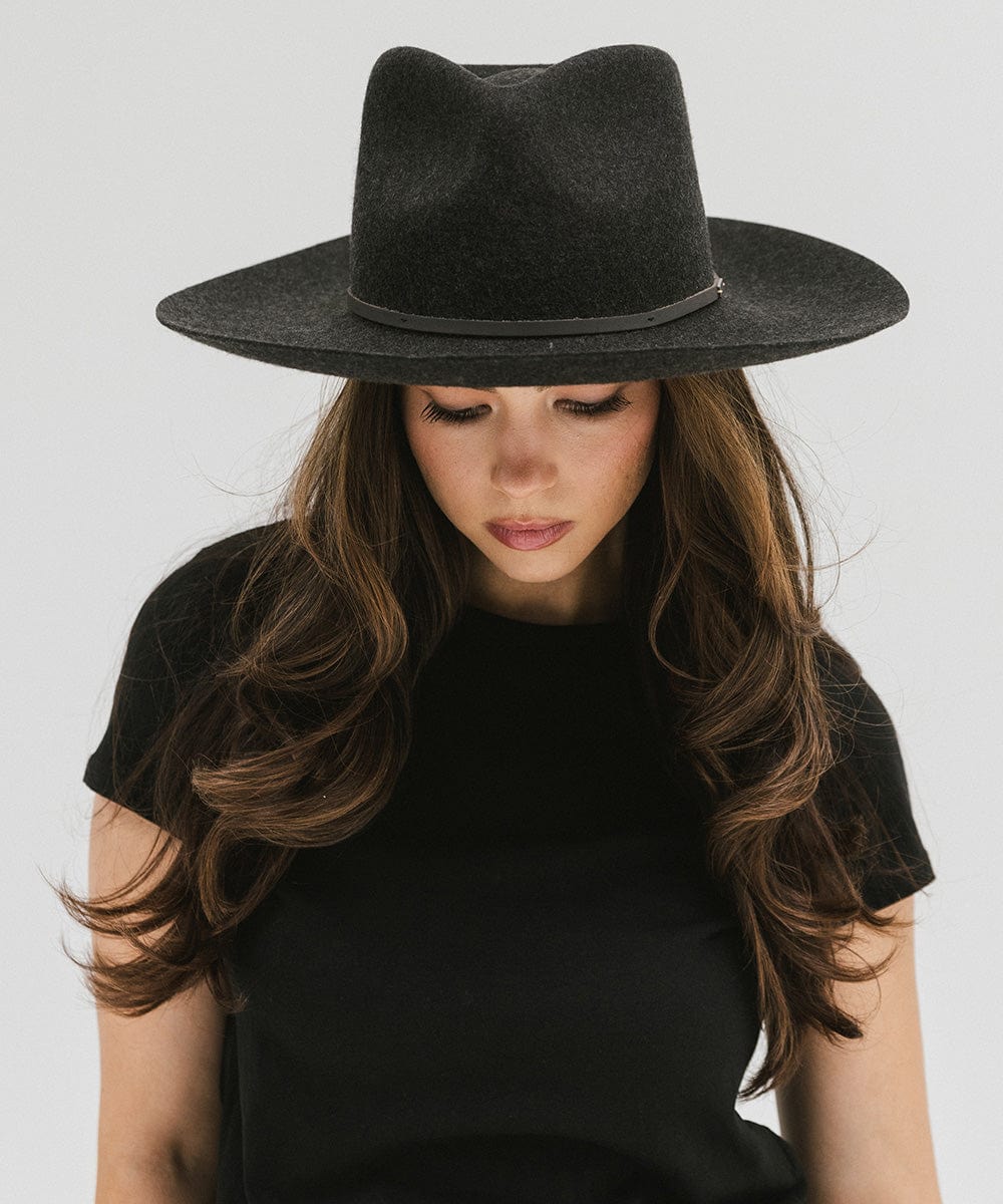 Woman wearing a mix charcoal colored Rowan Wide Brim Fedora Hat with a hat band and a black t-shirt against a plain background #color_mix charcoal