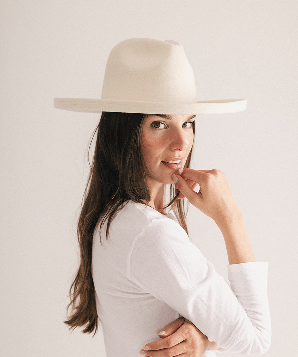 Woman wearing a white pencil brim felt fedora hat on a white background #color_off white