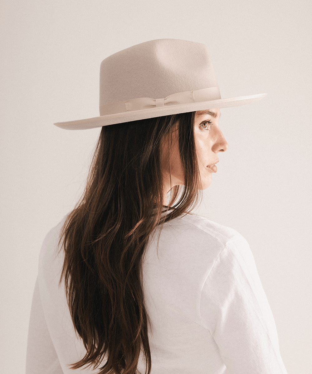Woman wearing a fedora hat with a band on a white background #color_ivory