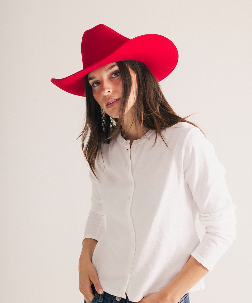 Woman wearing a red hat and white shirt on a plain background #color_cherry red