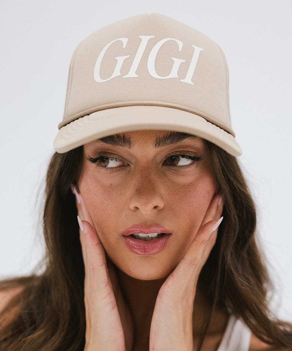 Woman wearing a tan cap with 'GIGI' text against a plain background #color_tan