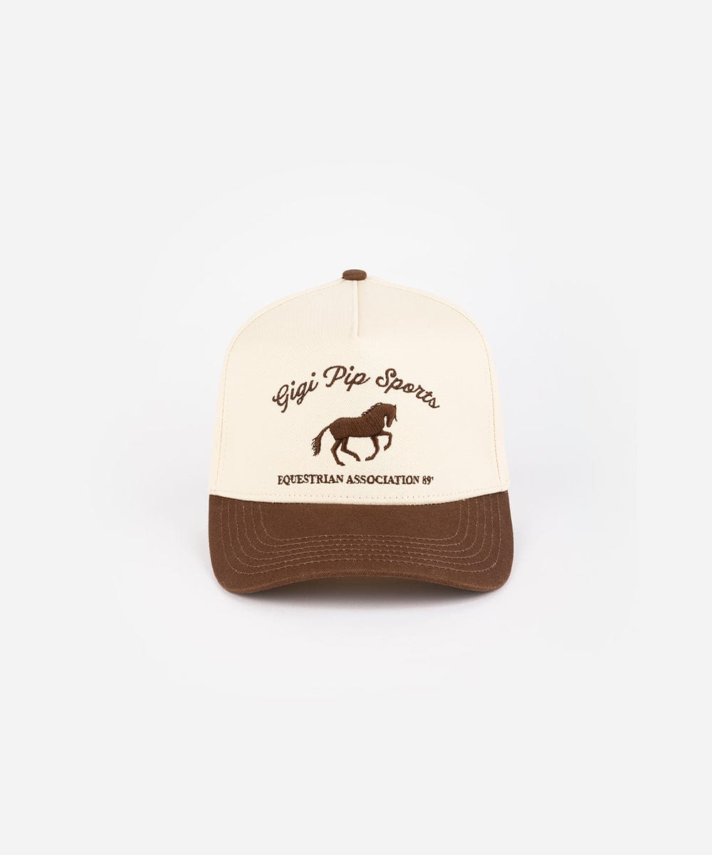 A cream and chocolate brown Trucker hat with 'Gigi Pip Sports' and horse logo on a white background #color_cream - chocolate brown