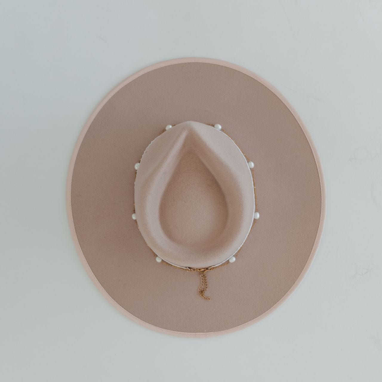 A beige hat with a gold pearl chain band on a plain background #color_gold