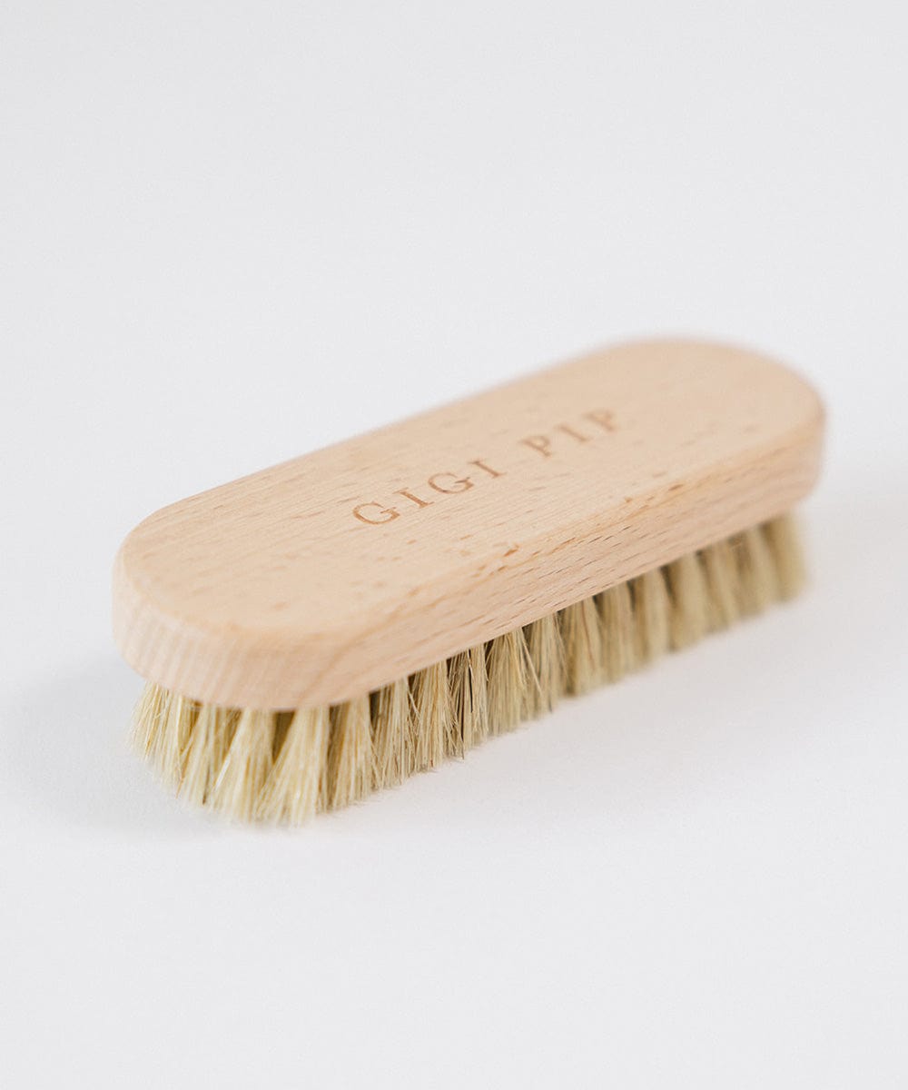 A cream colored hat brush with the text 'GIGI PIP' on a white background