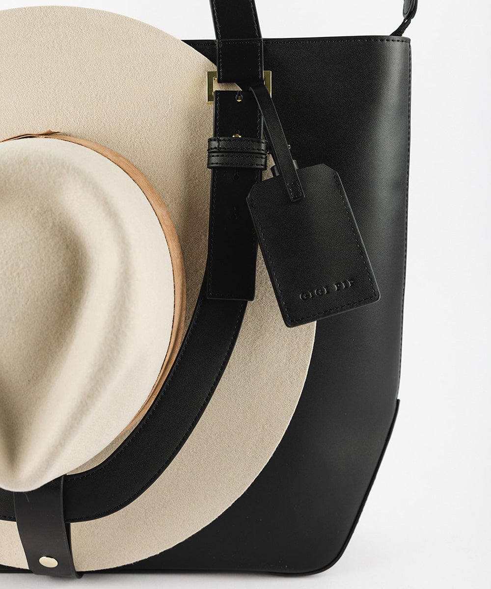 A black Hayes Hat Carrying Tote bag with a cream cowboy hat #color_black