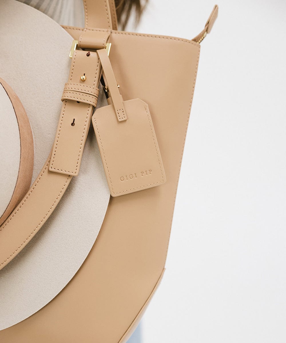 A beige leather bag with a brand label #color_tan
