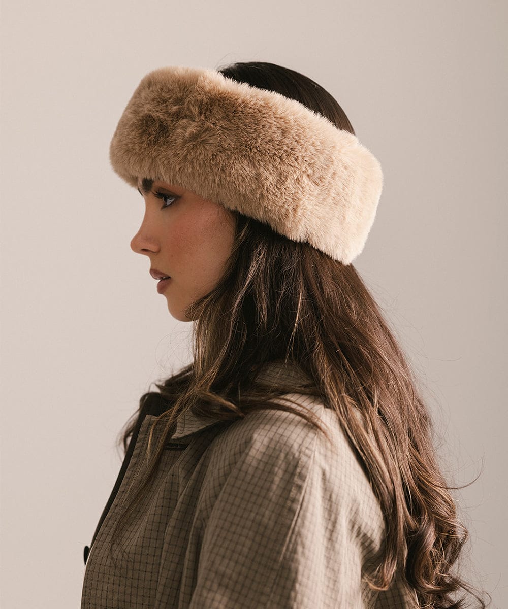 Woman wearing a beige fur headband against a neutral background #color_tan