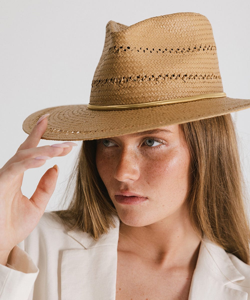 Woman wearing a brown hat with a gold chain hat band, looking sideways against a plain background #color_gold