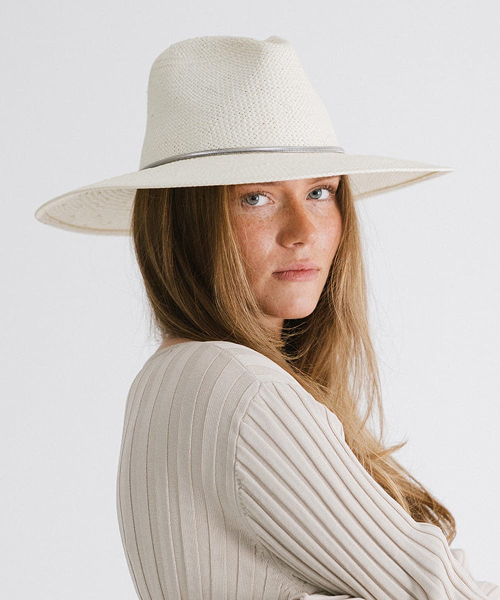 Woman wearing a white hat with a silver chain hat band and a white top, posing sideways against a plain background #color_silver