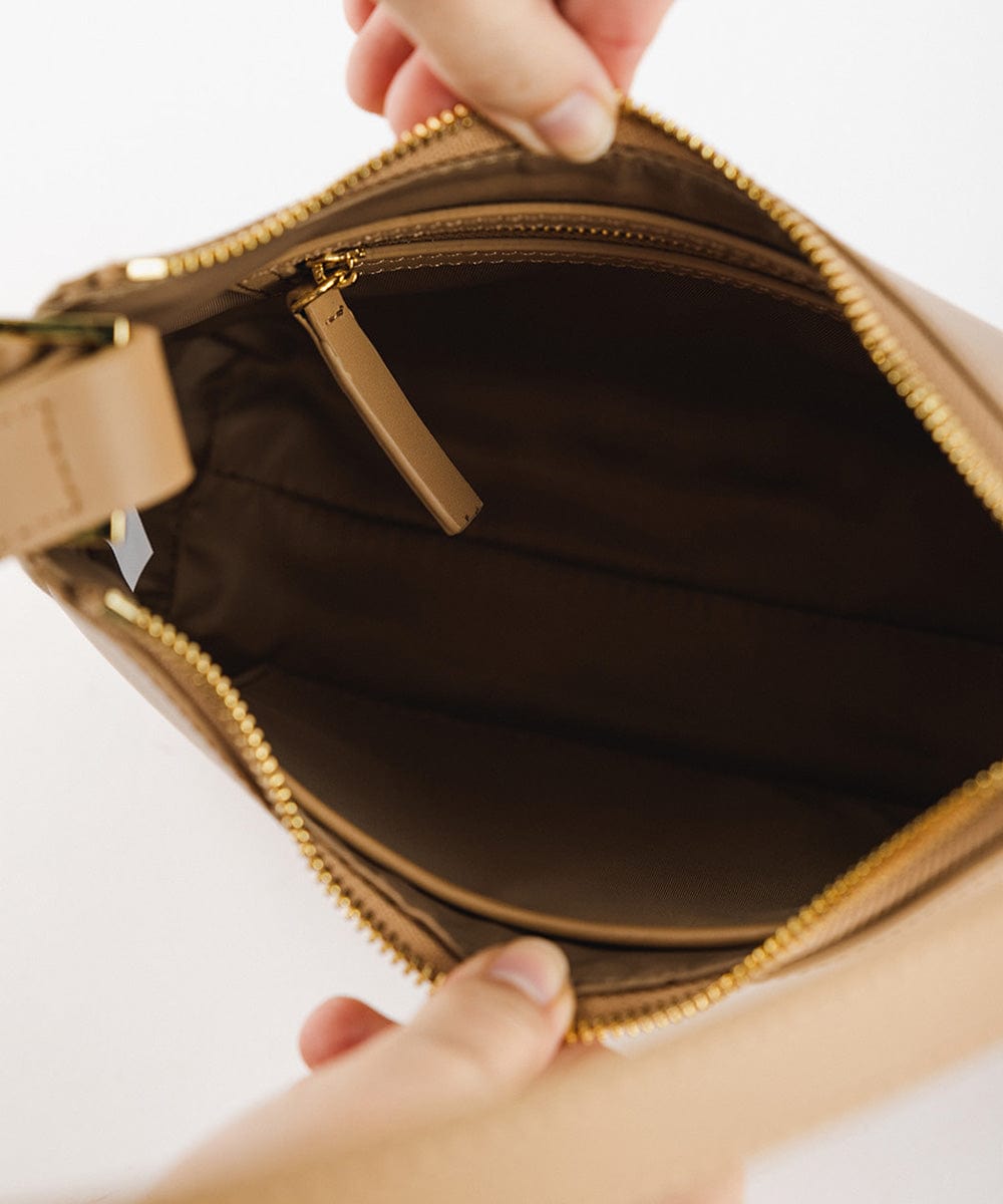 The inside of a tan genuine leather handbag on a plain background #color_tan