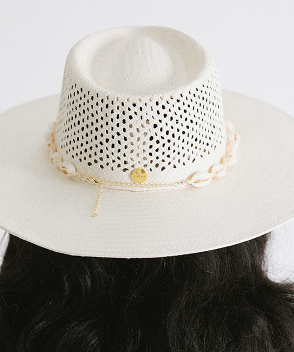 Woman wearing a white hat with a white shell hat band facing behind against a plain background #color_white