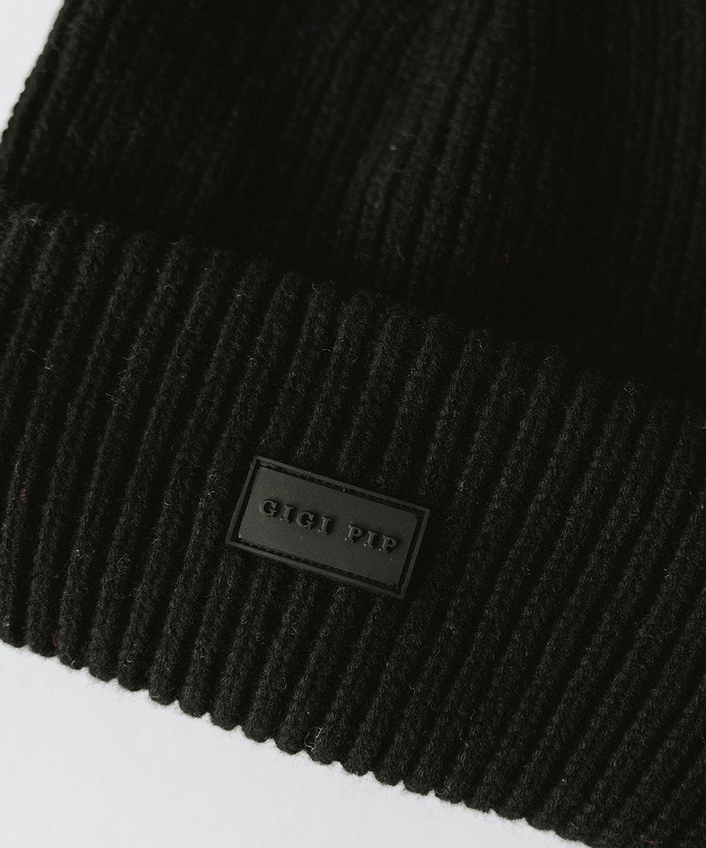 A black ribbed beanie with the brand label #color_black