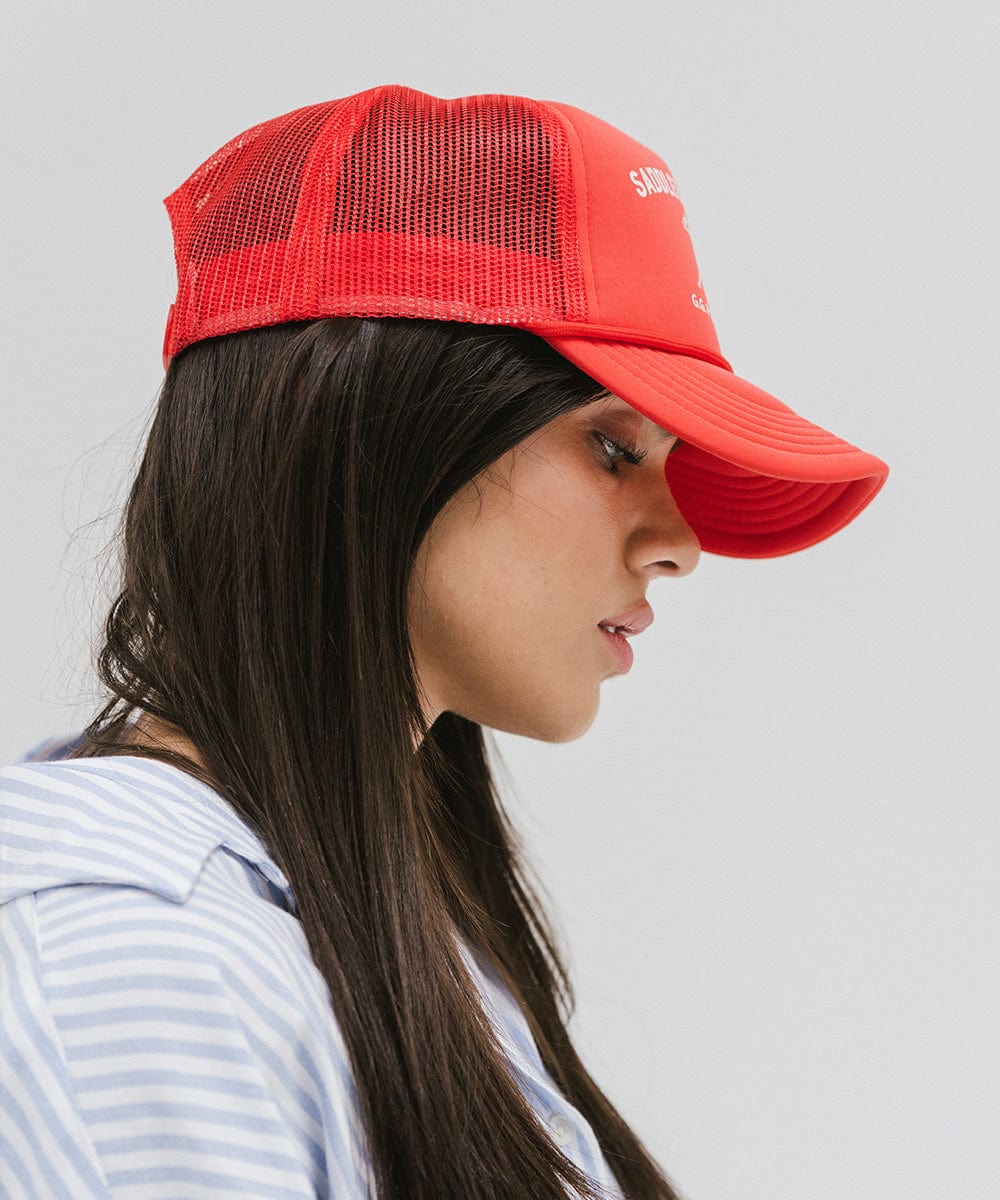 Woman wearing a vintage red colored cap with 'Saddleback Ranch' text and logo, and a light colored shirt, facing sideways against a plain background #color_vintage red
