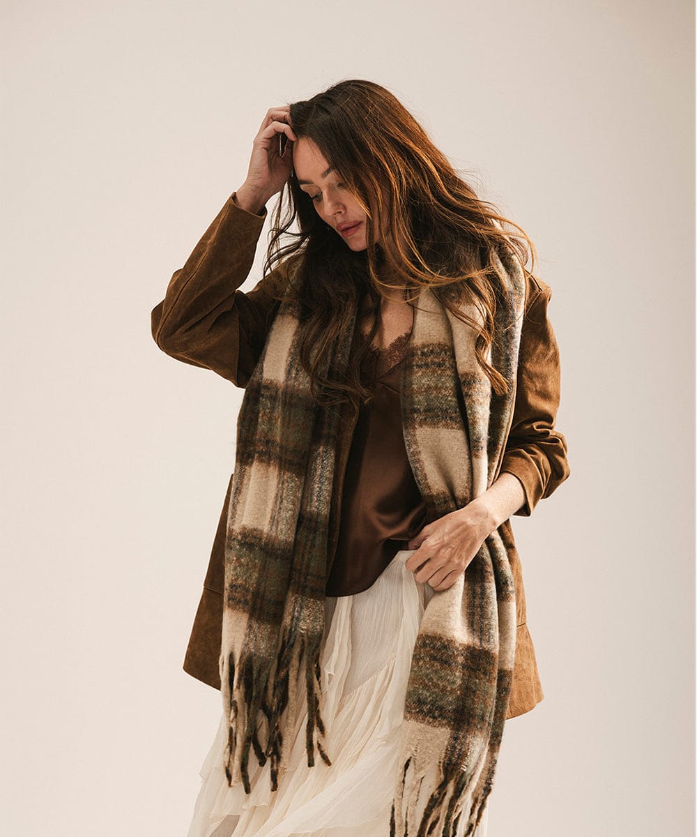 Woman wearing a plaid scarf and brown jacket against a plain background #color_cream - tan