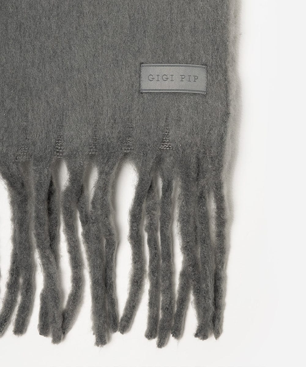 Gray scarf with fringe detail and 'Gigi Pip' label on a white background #color_grey