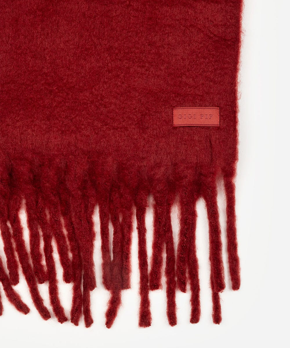 Red scarf with fringes and a brand label on a white background #color_burgundy