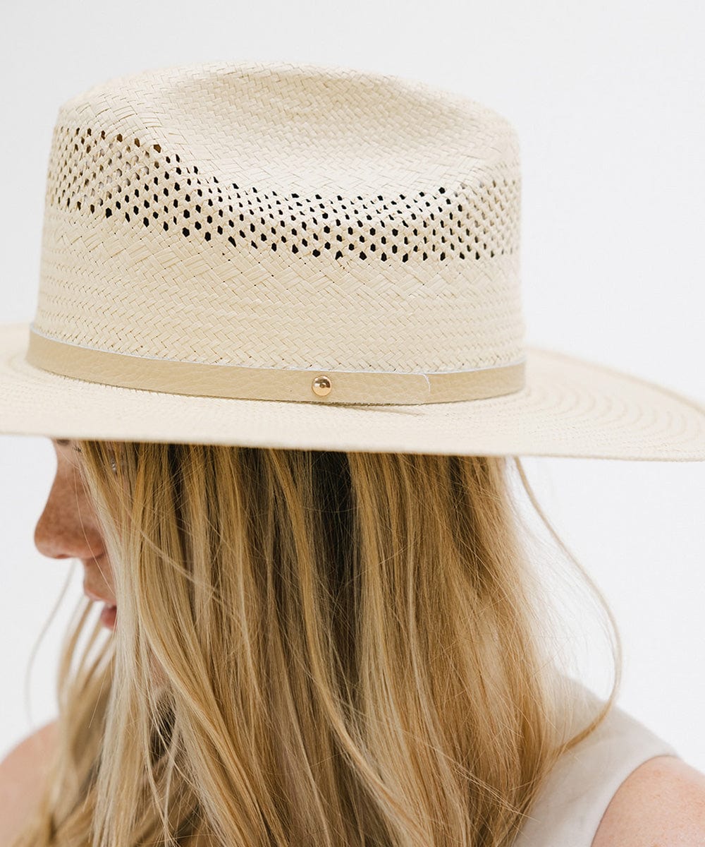 Woman wearing a natural colored straw cowboy hat with a hat band, facing sideways against a plain background #color_natural