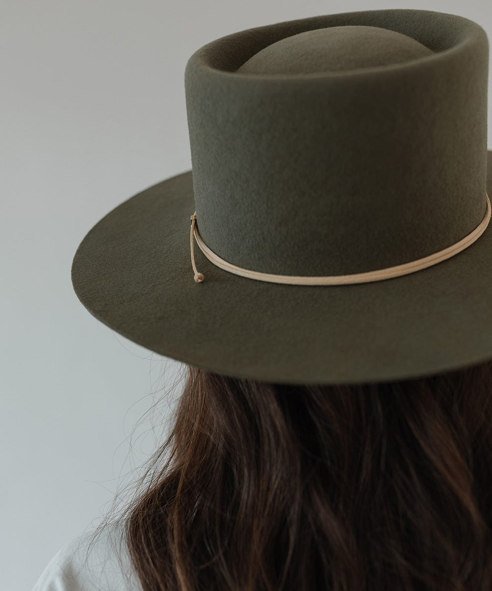 Woman wearing an olive hat with a cream suede band against a plain background #color_cream