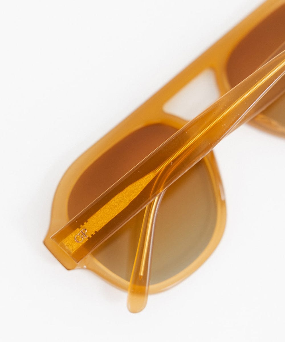 A pair of honey colored aviator sunglasses on a plain background #color_honey
