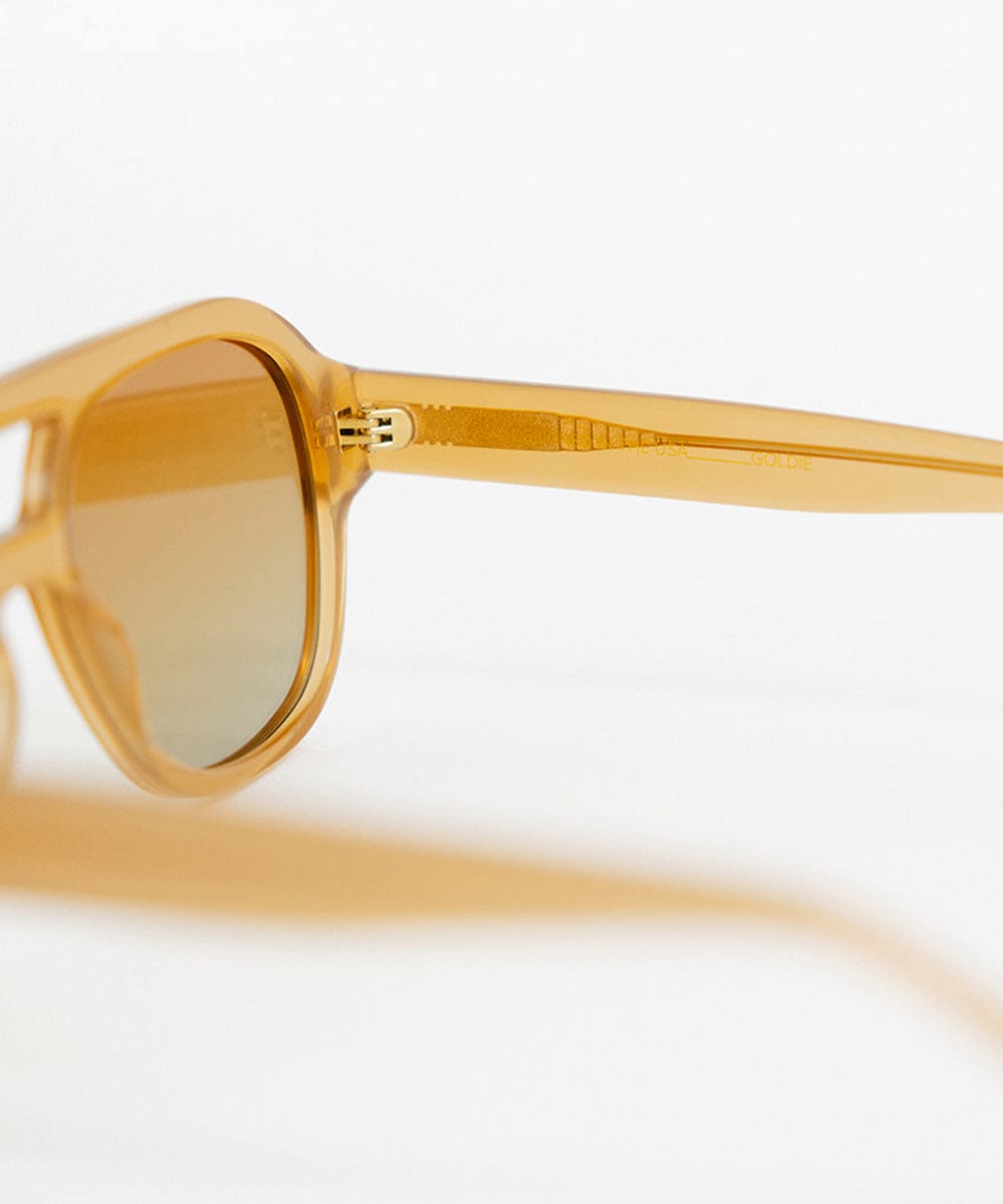 Honey colored aviator sunglasses against a plain background #color_honey
